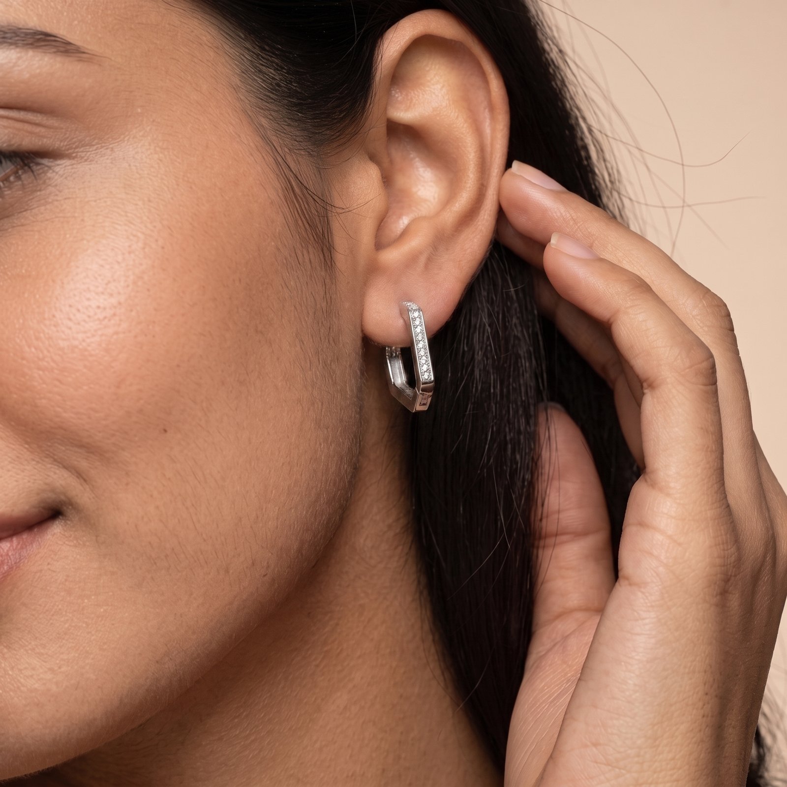 Woman wearing geometric pavé silver hoop earrings